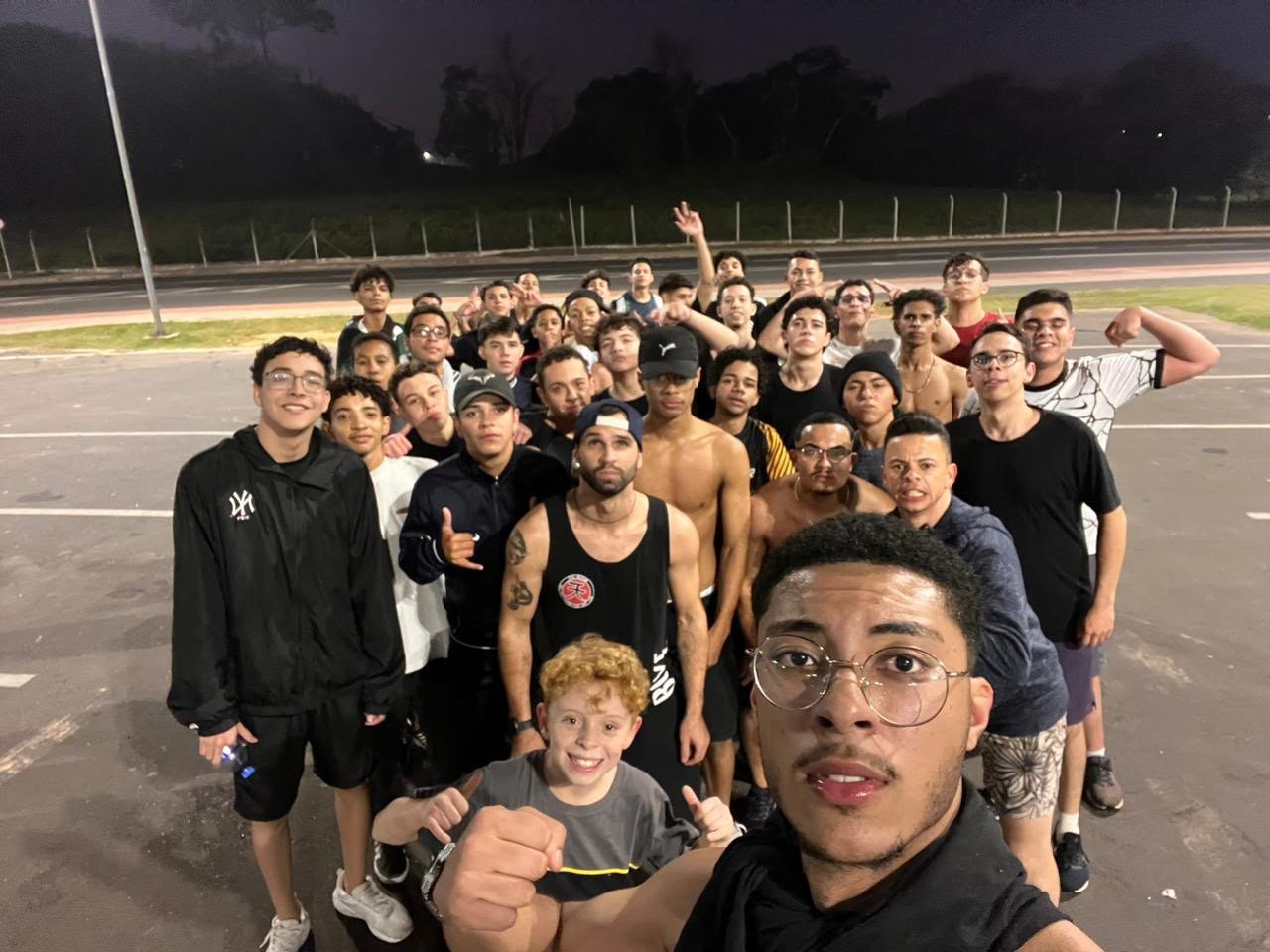 Selfie de um grupo grande de rapazes numa pista à noite